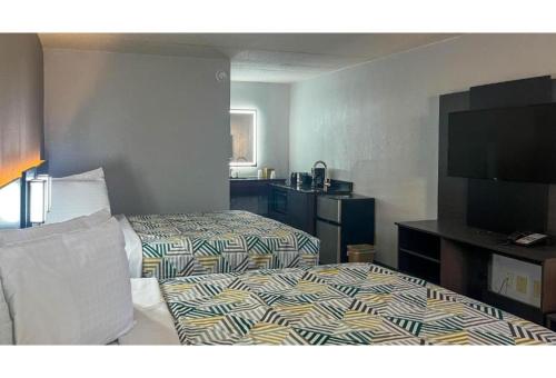 a hotel room with a bed and a flat screen tv at Studio 6 Spindale, NC Forest City in Spindale