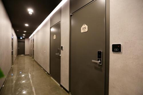 a row of elevator doors in a building with a sign on it at With U Hotel & Guesthouse in Sokcho