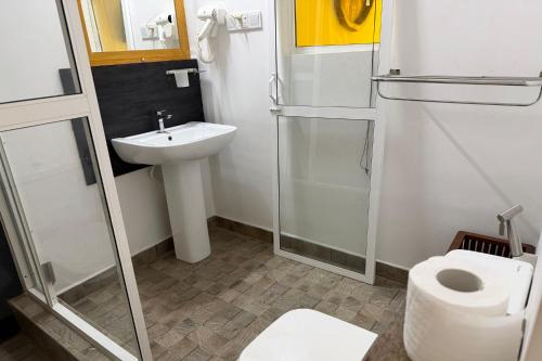 a bathroom with a sink and a toilet and a shower at Jkl MahaOya Villa in Wayikkal