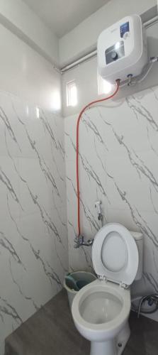 a bathroom with a toilet with a red hose at Toraja Hikari Homestay in Rantepao