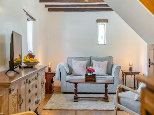 a living room with a blue couch and a table at The Bing in Buckland in the Moor
