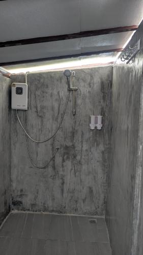 a shower with a hose attached to a concrete wall at Sunshine's Hill in Ko Lanta