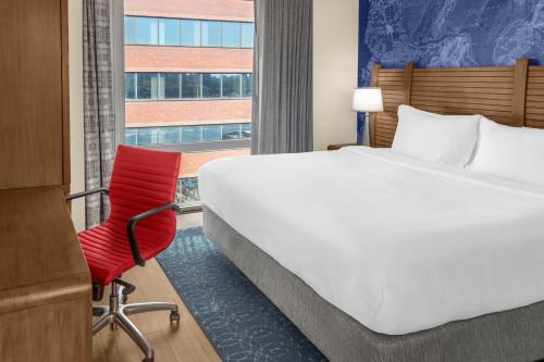 a hotel room with a bed and a red chair at Fairfield Inn by Marriott New York Manhattan/Financial District in New York