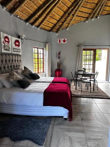 a bedroom with a large bed and a table at Banabaka spa and venue in White River