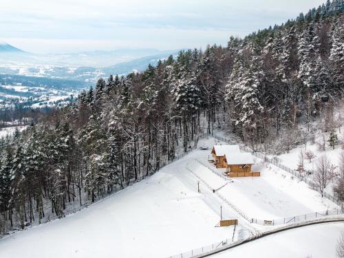 a snow covered mountain with a building on top of it at Łysogórska Polana Domki in Mordarka