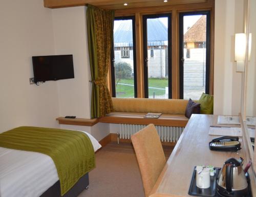 a hotel room with a bed and a table and a window at Canterbury Cathedral Lodge in Canterbury