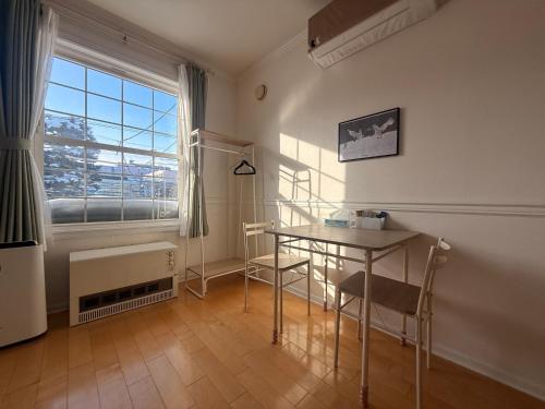 a room with a table and chairs and a window at Blume 中央区温馨小屋 地铁西18丁目站步行10分钟 in Sapporo