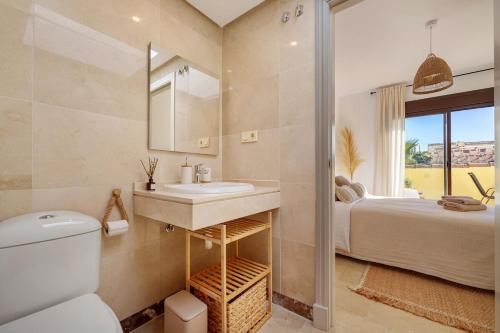 a bathroom with a sink and a toilet and a bed at Duquesa Sea & Sun in Manilva