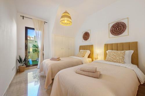 two beds in a bedroom with white walls at Duquesa Sea & Sun in Manilva