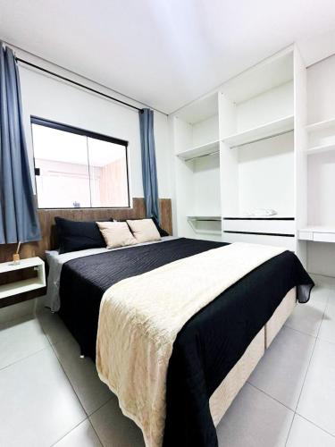 a bedroom with a large bed and a large window at Lindo flat próximo do centro in Formosa