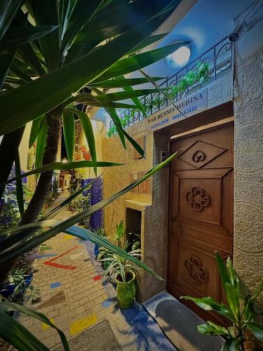 a building with a wooden door and some plants at Dar Bennis médina in Rabat