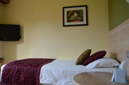 a bedroom with a bed with white sheets and pillows at Canterbury Cathedral Lodge in Canterbury