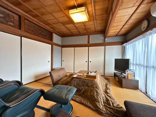 a living room with a couch and a tv at ステイ和屋Ooasa徳島で家族とのんびりできる和室宿 in Naruto