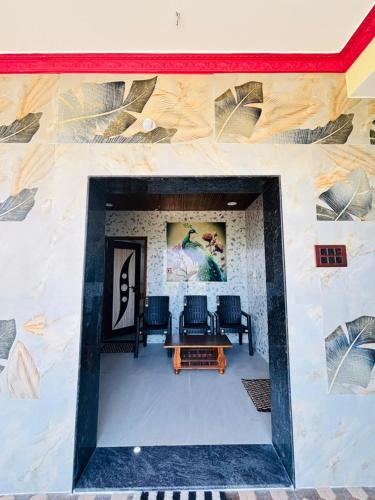 a room with chairs and a table on a wall at Tunga sadan in Mādhavaram