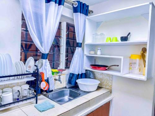 a kitchen with a sink and a counter with dishes at GILGAL Homes in Kisii