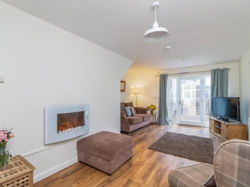 a living room with a fireplace and a tv at Foxglove - Uk51200 in Staintondale