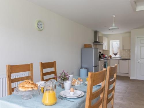 a kitchen with a table with bread and orange juice at Foxglove - Uk51200 in Staintondale