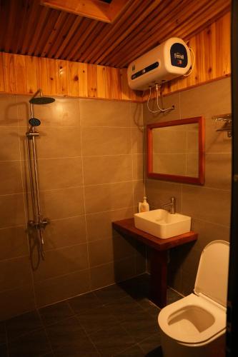 a bathroom with a toilet and a sink and a shower at H'mong Village Homestay in Sapa