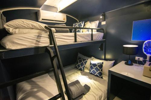 a dorm room with two bunk beds and a desk at Baan Rot Fai Krabi Platform 3 in Ao Nam Mao