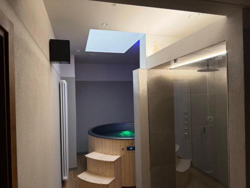 a bathroom with a tub in the ceiling with a tv at Hotel Chalet Seggiovia in Pontechianale
