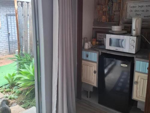 a kitchen with a microwave and a tv on a counter at SomethingElz@Grace in Pretoria