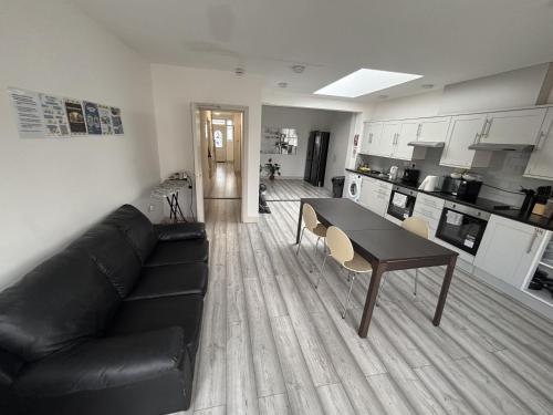 a living room with a black couch and a table at Streatham Rooms in London