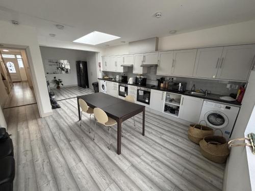 a kitchen with a table and chairs in a room at Streatham Rooms in London