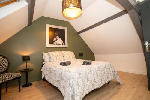 a bedroom with a bed and a green wall at Chez Léon in Hasnon