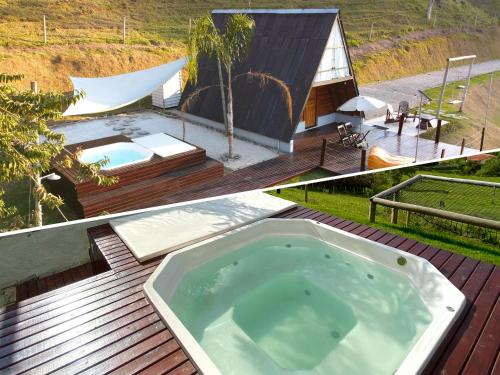 a bath tub sitting on a deck next to a house at Chalesunset in Santa Isabel