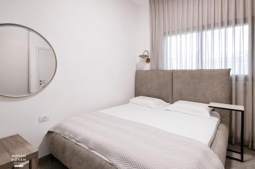 a bedroom with a large bed and a mirror at פסגת יובלים 2 in Qiryat Shemona