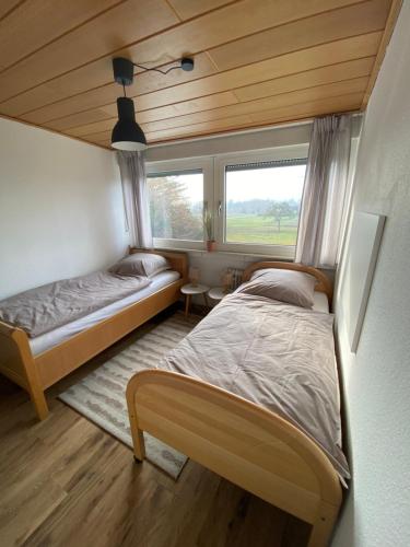 two beds in a small room with a window at 3-Zimmer-Ferienwohnung in Werl