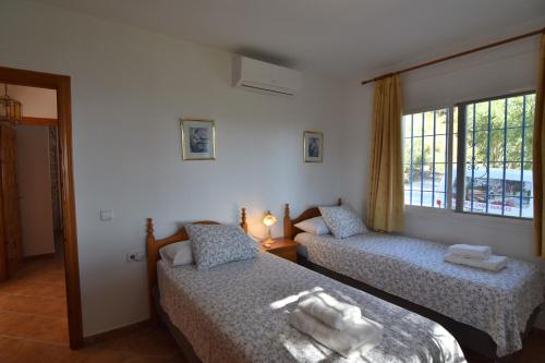a bedroom with two beds and a window at Villa La Frasca with private Pool in Corumbela