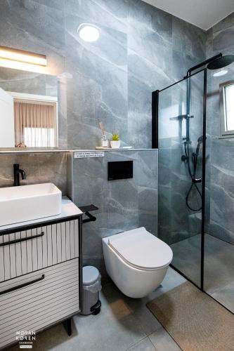 a bathroom with a toilet and a sink and a shower at פסגת יובלים 2 in Qiryat Shemona