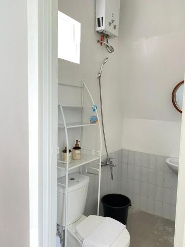 a white bathroom with a toilet and a sink at villa heve glamping in Kaliurang