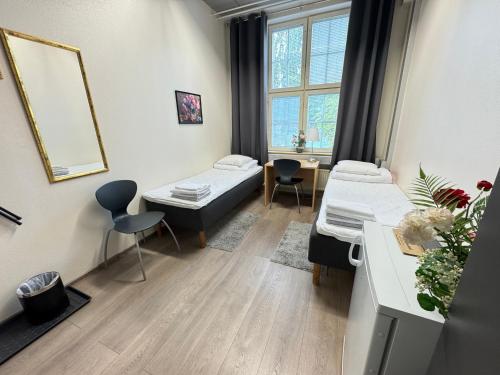 a hospital room with two beds and a window at Hostel Hermanni in Kuopio