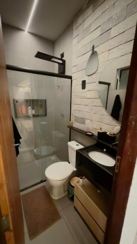 a bathroom with a toilet and a sink and a shower at Flat em Carapibus moderno e aconchegante in Conde