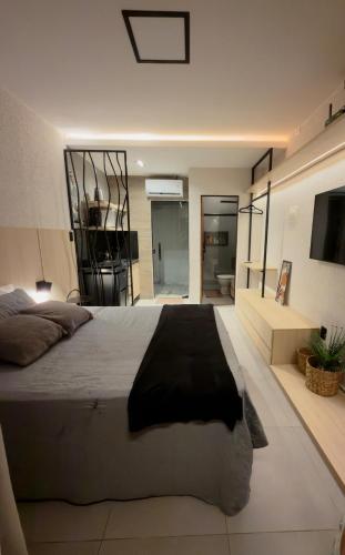 a bedroom with a large bed and a bathroom at Flat em Carapibus moderno e aconchegante in Conde