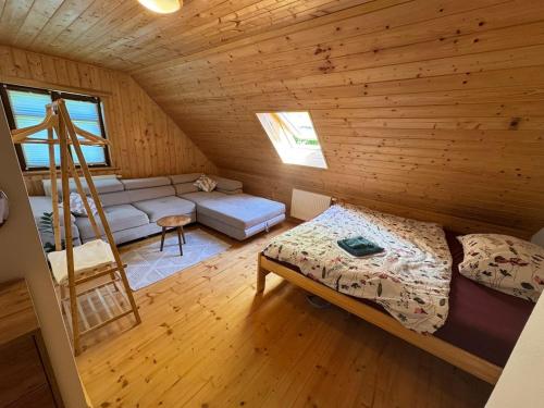 a room with a bed and a ladder in a log cabin at Roubenka Liduška in Mikulovice