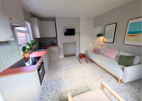 a living room with a couch and a kitchen at Tranquil flat in vibrant Nether Edge in Nether Edge