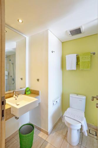 a bathroom with a white toilet and a sink at MaxOneHotels at Bukit Jimbaran in Jimbaran