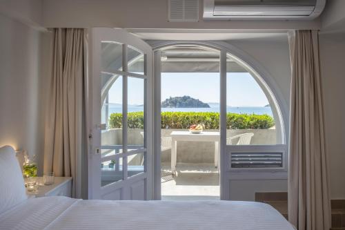 a bedroom with a bed and a view of the ocean at Nelly's Apartments in Tolo