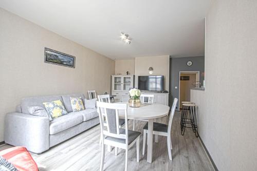 a living room with a table and a couch at Le nid Saint Jean apartment in the heart of the city in Bayeux