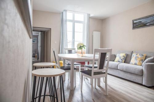 a living room with a table and chairs and a couch at Le nid Saint Jean apartment in the heart of the city in Bayeux