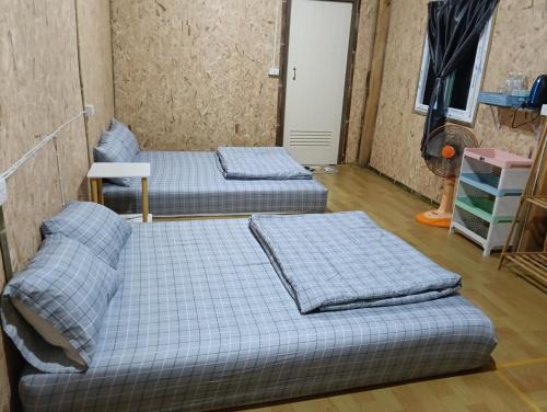 two beds sitting in a room with at จรรยา โฮมสเตย์ in Chom Thong