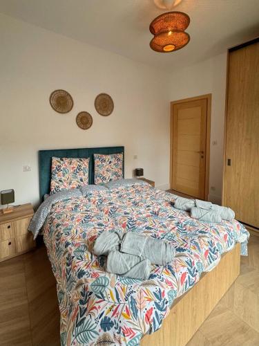a bedroom with a large bed with a colorful comforter at Esprit Lubéron, Le Romarin, logement entier in Le Thor