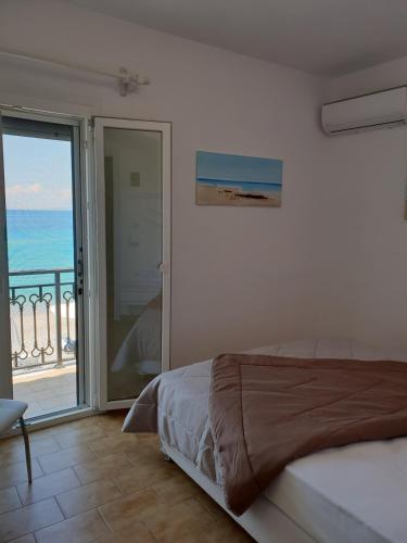 a bedroom with a bed and a view of the ocean at Beachfront villa Ioanna in Kokkari