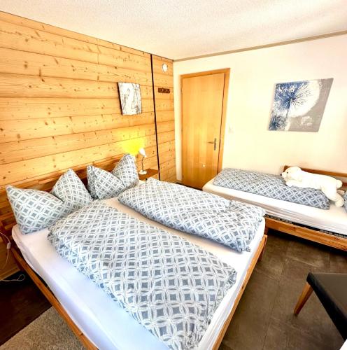 two beds in a room with wooden walls at Apartments Chalet Tatyana in Leukerbad