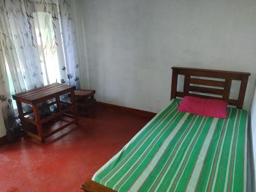 a small room with a bed and a table at Great Resort in Nikawatawana