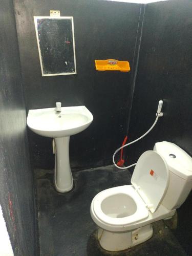a bathroom with a white toilet and a sink at Great Resort in Nikawatawana