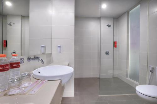 un bagno bianco con lavandino e doccia di favehotel Sudirman Bojonegoro a Bojonegoro